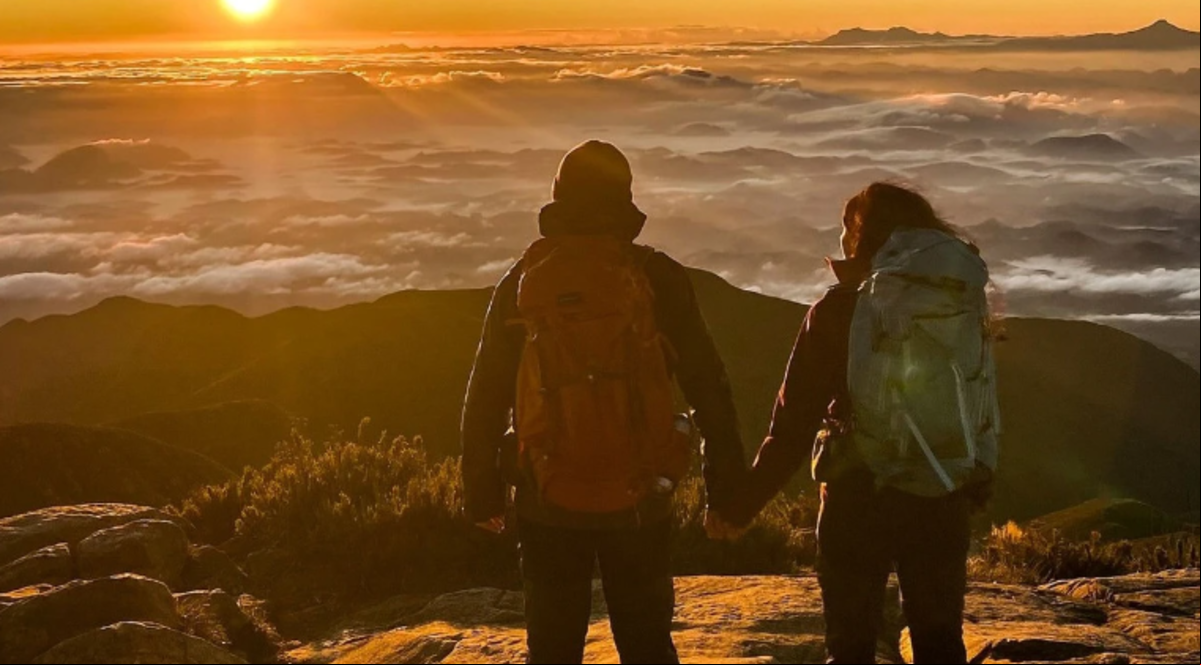Casal observa o nascer do sol no pico da Bandeira, um dos locais mais frios de Minas